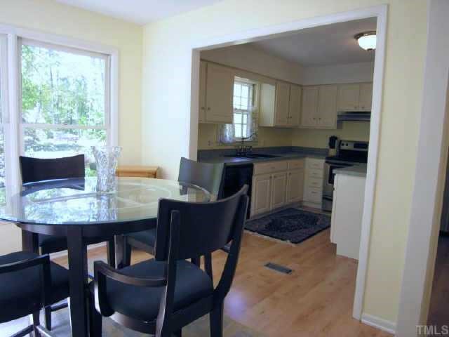 8900 Brandon Station Road Raleigh, NC 27613 - Photo 8 of 10 a kitchen with a table chairs and a refrigerator