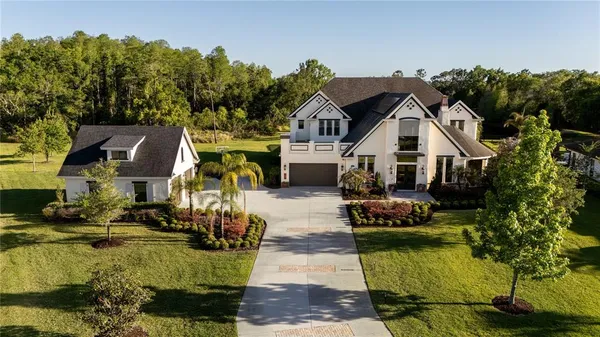 an aerial view of a house with a garden and lake view