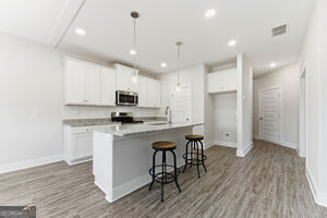 11149 Cornerstone Lane Hampton, GA 30228 - Photo 10 of 29 a kitchen with stainless steel appliances granite countertop a refrigerator a stove top oven a sink dishwasher and white cabinets with wooden floor