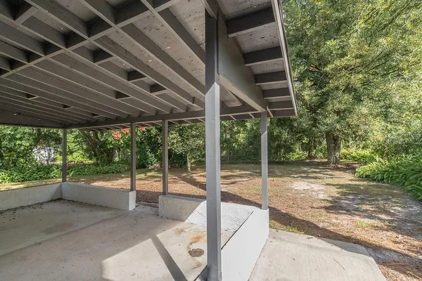 a view of a porch with furniture and a yard