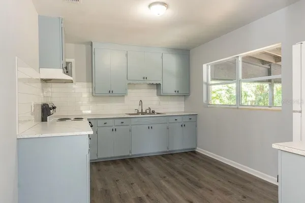 a kitchen with sink stove and cabinets