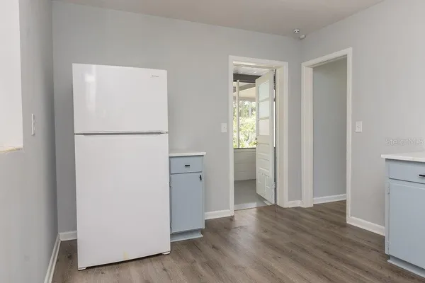 a view of a kitchen with wooden floor and refrigerator