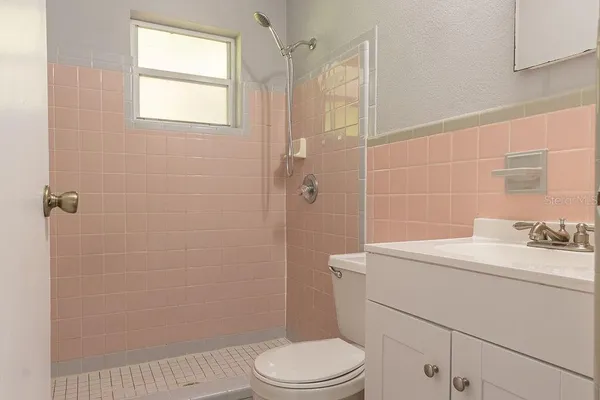 a bathroom with a toilet sink vanity and shower