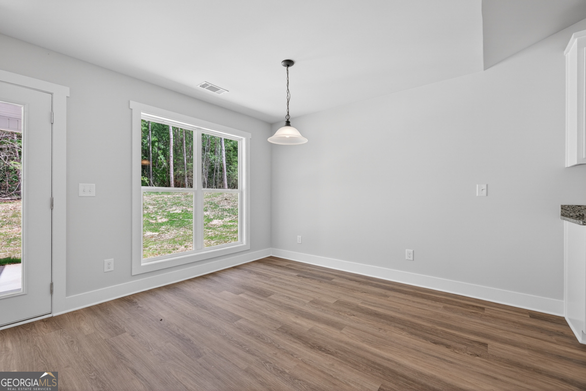 206 Airport Road, Unit 11 Canon, GA 30520 - Photo 18 of 34 a view of an empty room with wooden floor and a window