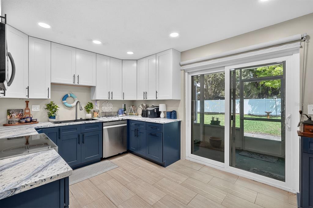 327 London Road Daytona Beach, FL 32117 - Photo 11 of 42 a kitchen with stainless steel appliances granite countertop a refrigerator a sink dishwasher a stove and white countertops with wooden floor