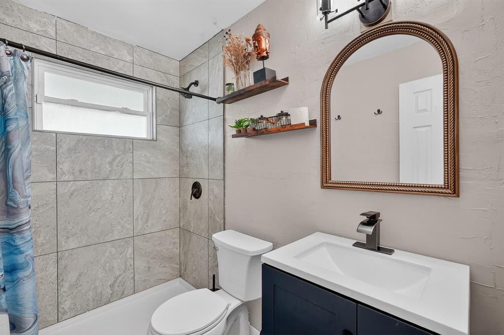 327 London Road Daytona Beach, FL 32117 - Photo 17 of 42 a bathroom with a sink a toilet and shower