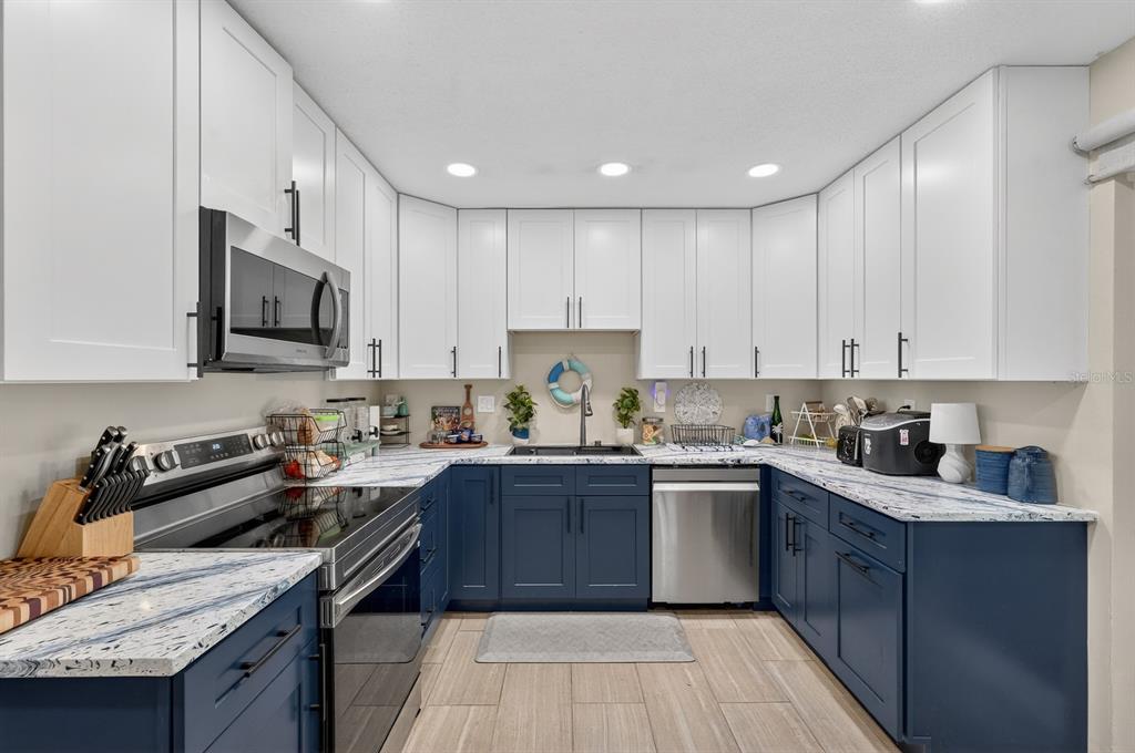 327 London Road Daytona Beach, FL 32117 - Photo 7 of 42 a kitchen with stainless steel appliances granite countertop wooden cabinets stove a sink and dishwasher