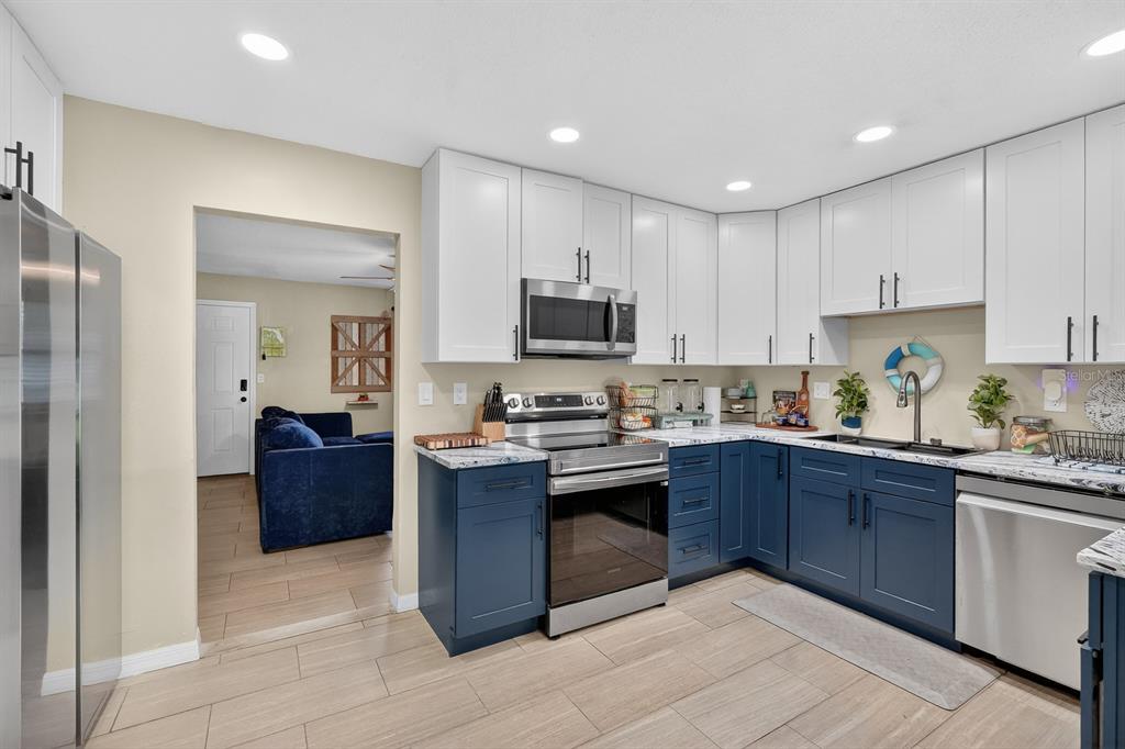 327 London Road Daytona Beach, FL 32117 - Photo 8 of 42 a kitchen with granite countertop a stove top oven and cabinets
