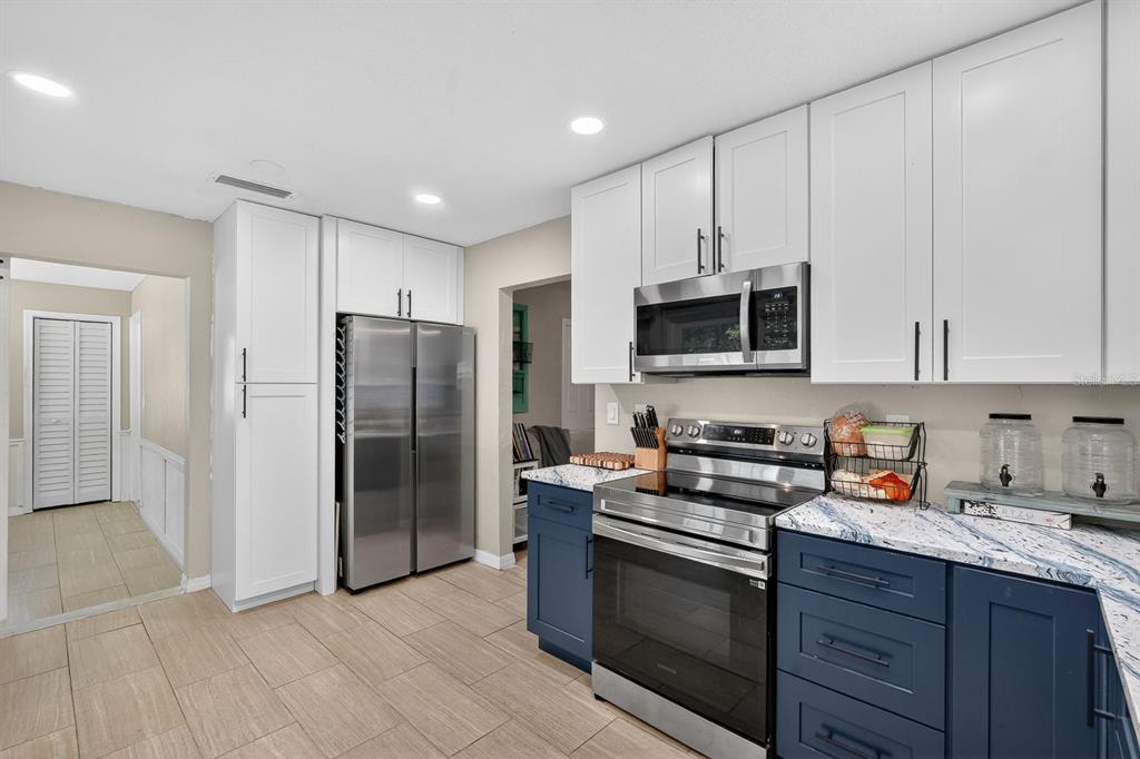 327 London Road Daytona Beach, FL 32117 - Photo 9 of 42 a kitchen with stainless steel appliances granite countertop a refrigerator stove and microwave