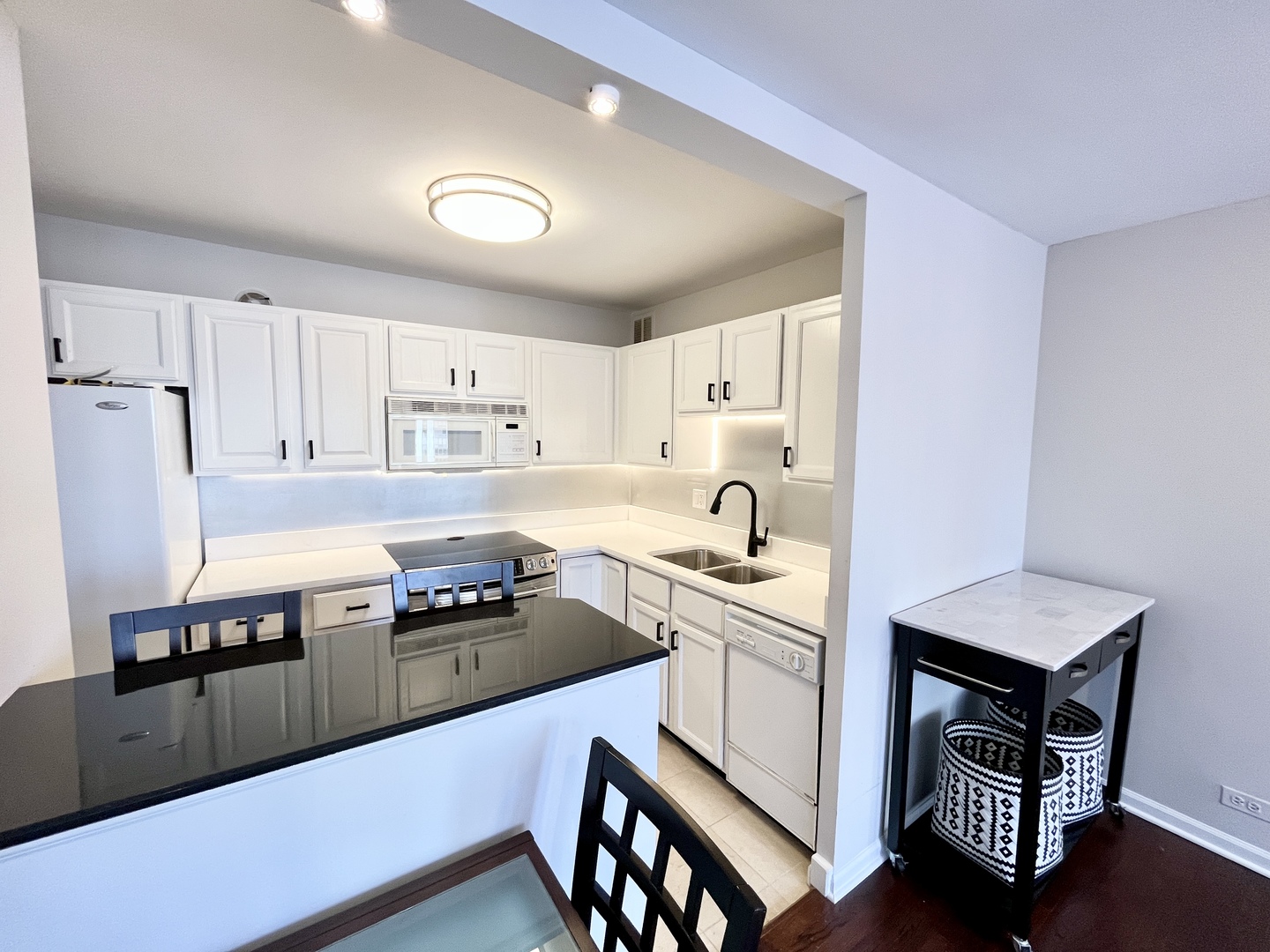 100 East Walton Place, Unit 14A Chicago, IL 60611 - Photo 3 of 19 a kitchen with a sink a stove and chairs