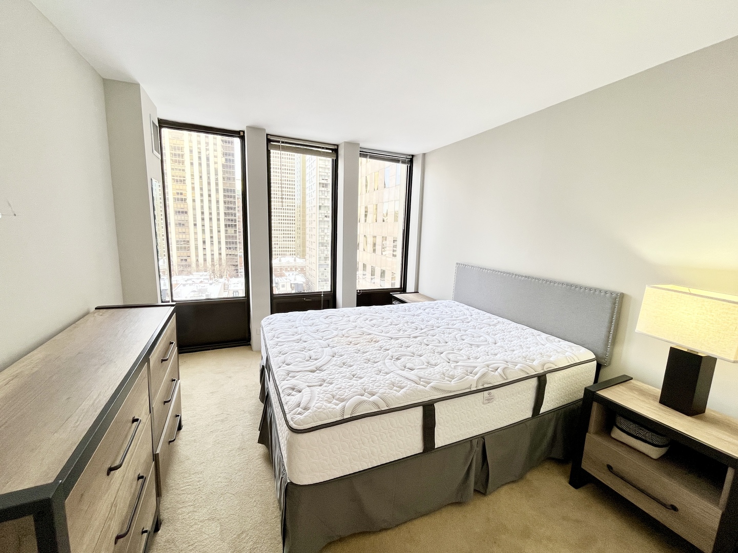 100 East Walton Place, Unit 14A Chicago, IL 60611 - Photo 8 of 19 a bedroom with a bed and large windows