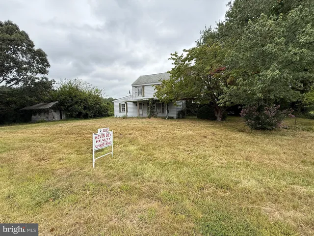 a view of a swimming pool with lawn chairs under an umbrella