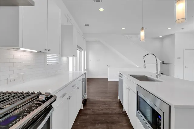 a kitchen with a sink stove and cabinets