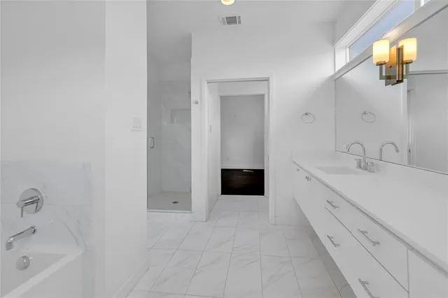 a spacious bathroom with a bathtub sink and mirror