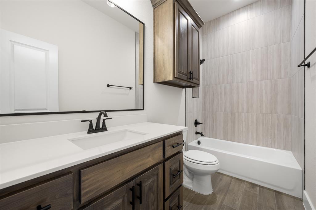 4867 Prairie Sky Lane DISH, TX 76247 - Photo 20 of 27 a bathroom with a granite countertop sink toilet a mirror and bathtub
