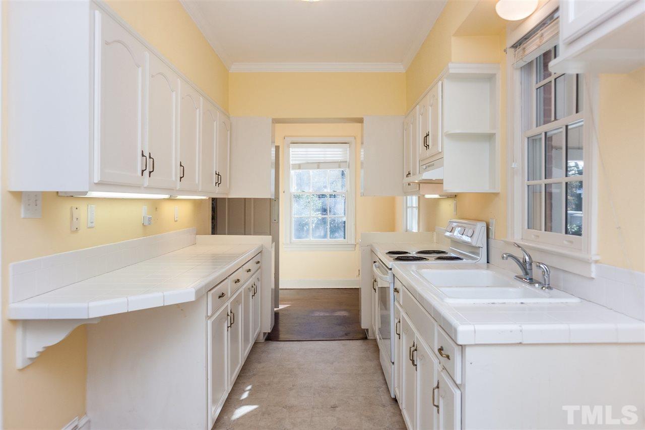 1707 Jarvis Street Raleigh, NC 27608 - Photo 12 of 25 a kitchen with a sink stove and cabinets