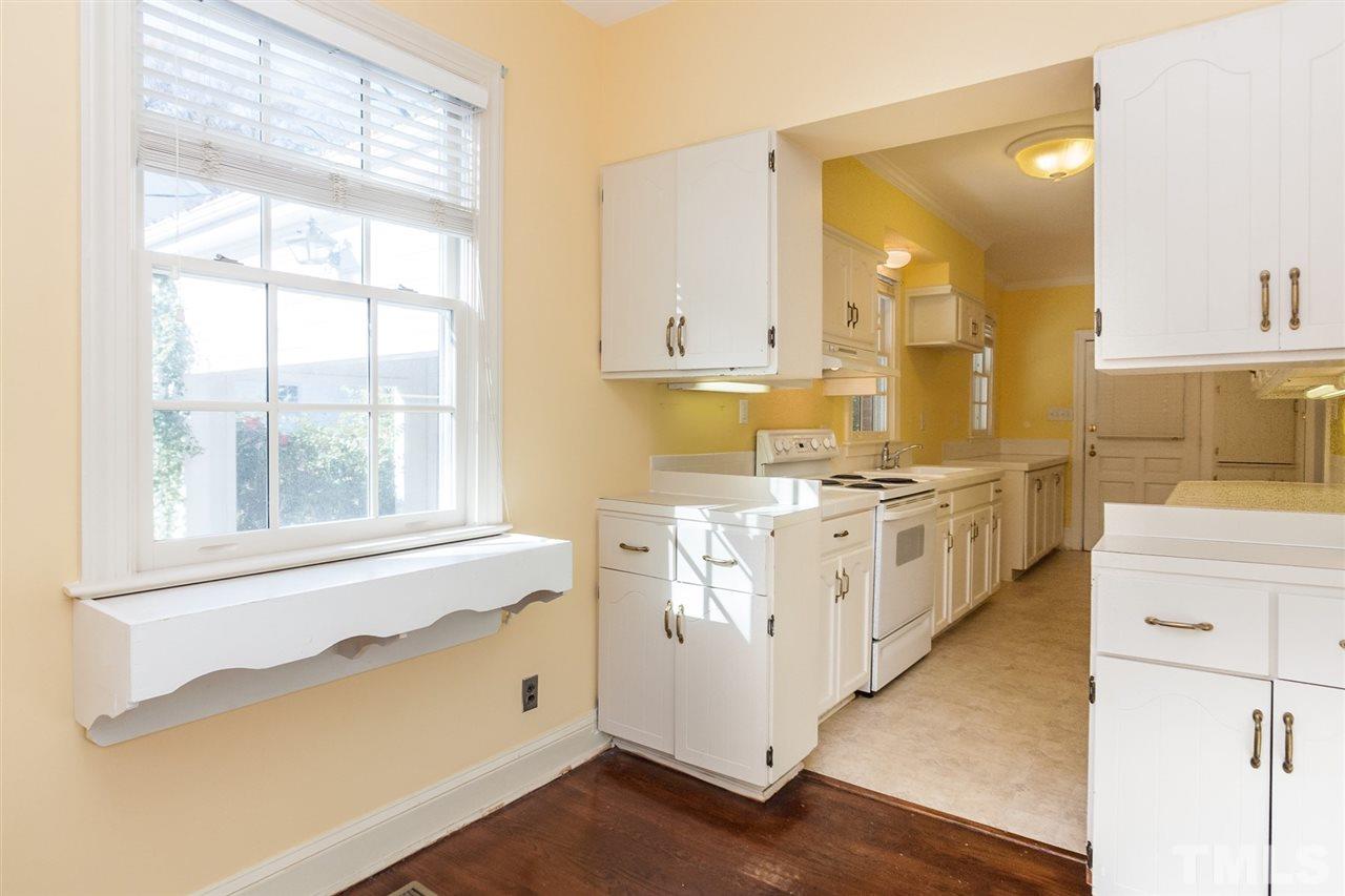 1707 Jarvis Street Raleigh, NC 27608 - Photo 14 of 25 a kitchen with white cabinets and white appliances