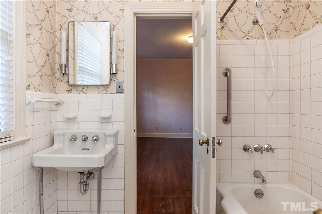 1707 Jarvis Street Raleigh, NC 27608 - Photo 18 of 25 a bathroom with a sink a mirror and shower