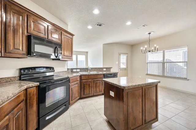 a kitchen with stainless steel appliances granite countertop wooden cabinets sink and stove