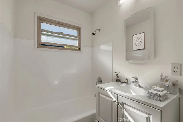 a bathroom with a granite countertop sink a mirror and a bathtub