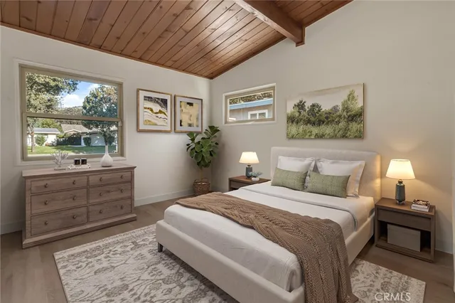 a bedroom with a bed and a dresser next to a window