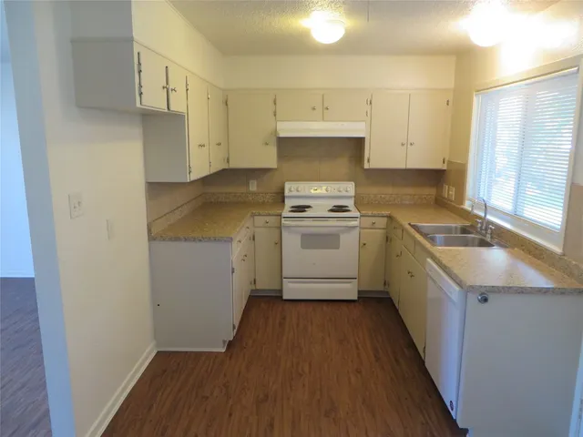 a kitchen with a sink cabinets stainless steel appliances and a window