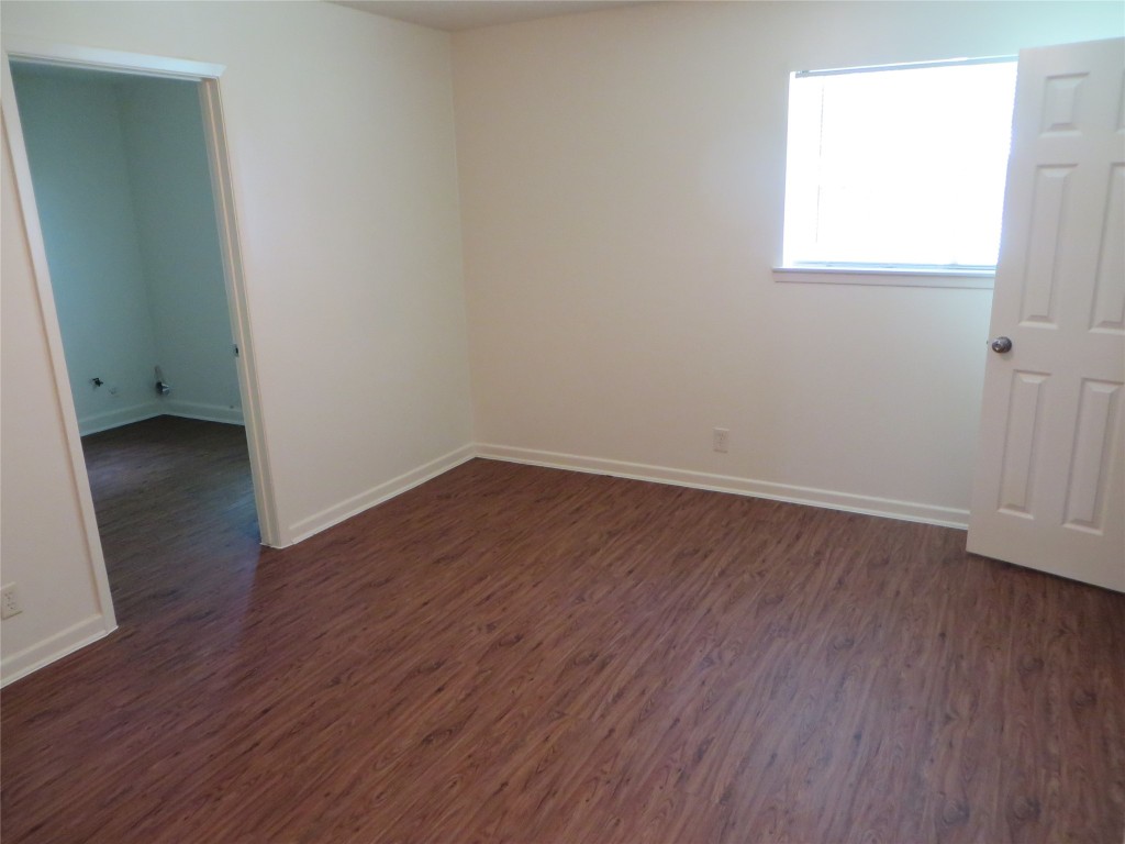812 Ranch Road, Unit B Georgetown, TX 78628 - Photo 22 of 31 an empty room with wooden floor and windows