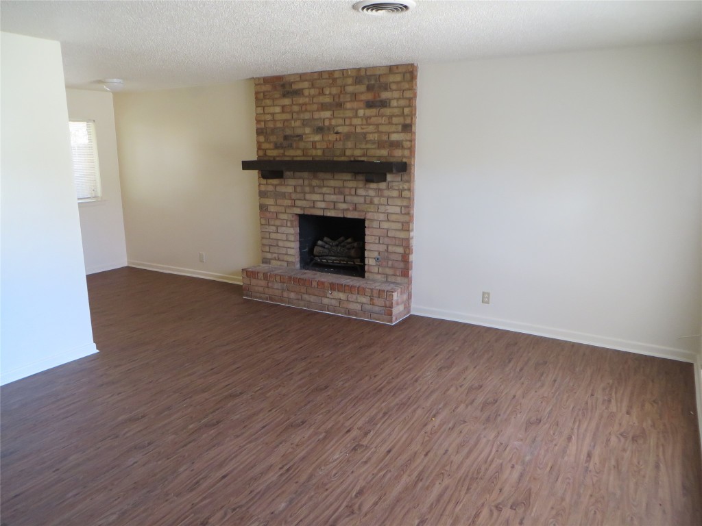 812 Ranch Road, Unit B Georgetown, TX 78628 - Photo 8 of 31 a view of empty room with wooden floor and fireplace