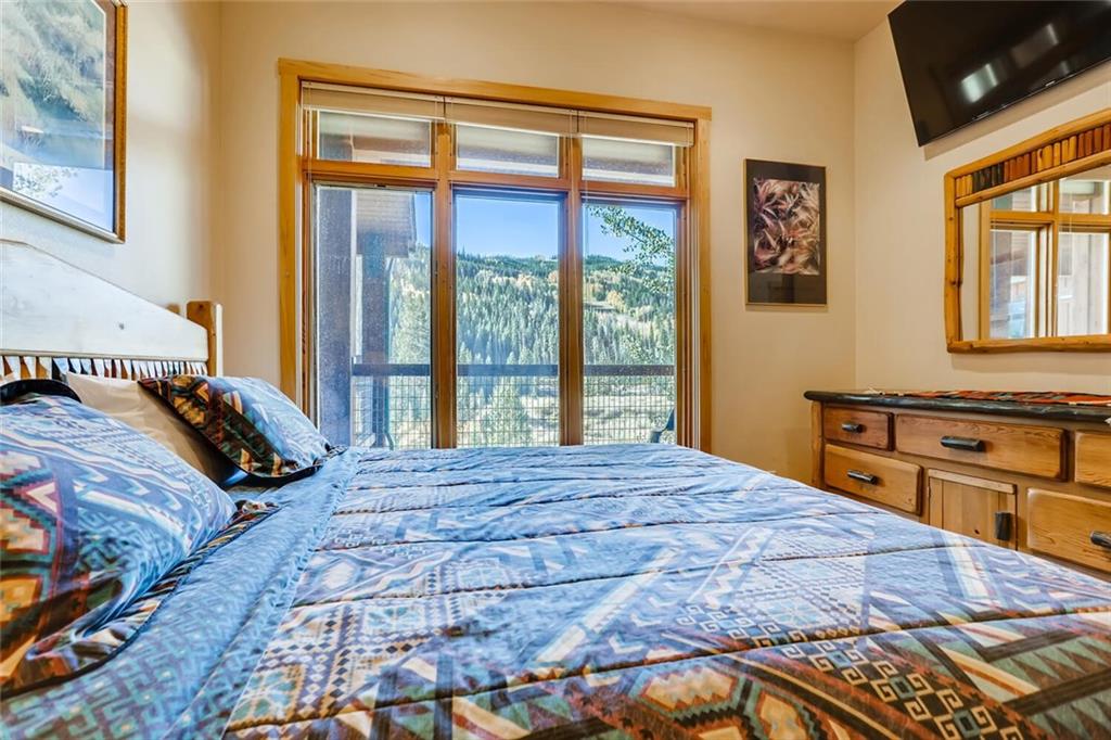 56 River Run Road, Unit 301 Keystone, CO 80435 - Photo 14 of 30 a bedroom with a bed and a flat tv screen on dresser
