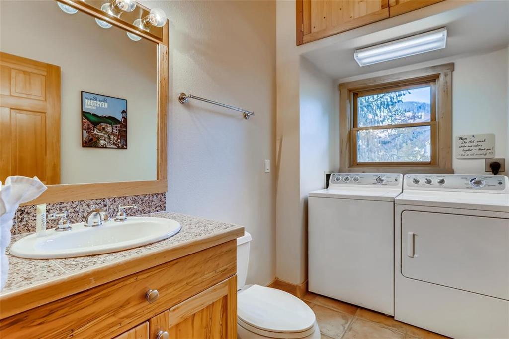 56 River Run Road, Unit 301 Keystone, CO 80435 - Photo 20 of 30 a bathroom with a sink a mirror a toilet and a window