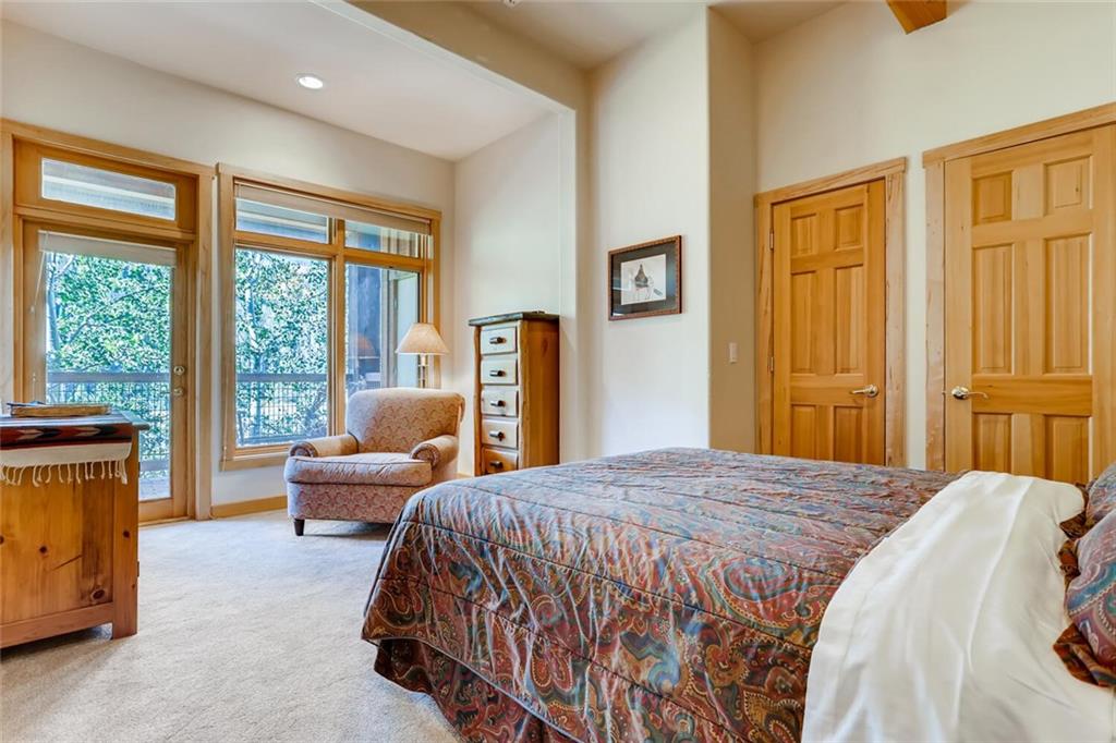 56 River Run Road, Unit 301 Keystone, CO 80435 - Photo 23 of 30 a bedroom with a bed and glass window
