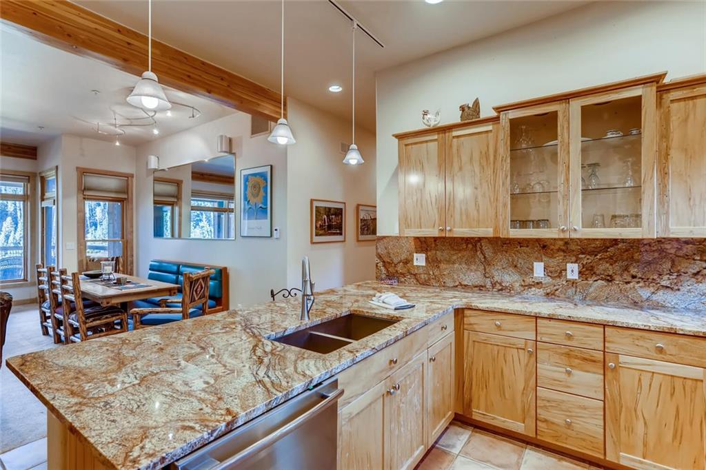 56 River Run Road, Unit 301 Keystone, CO 80435 - Photo 5 of 30 a kitchen with a sink stove and wooden cabinets