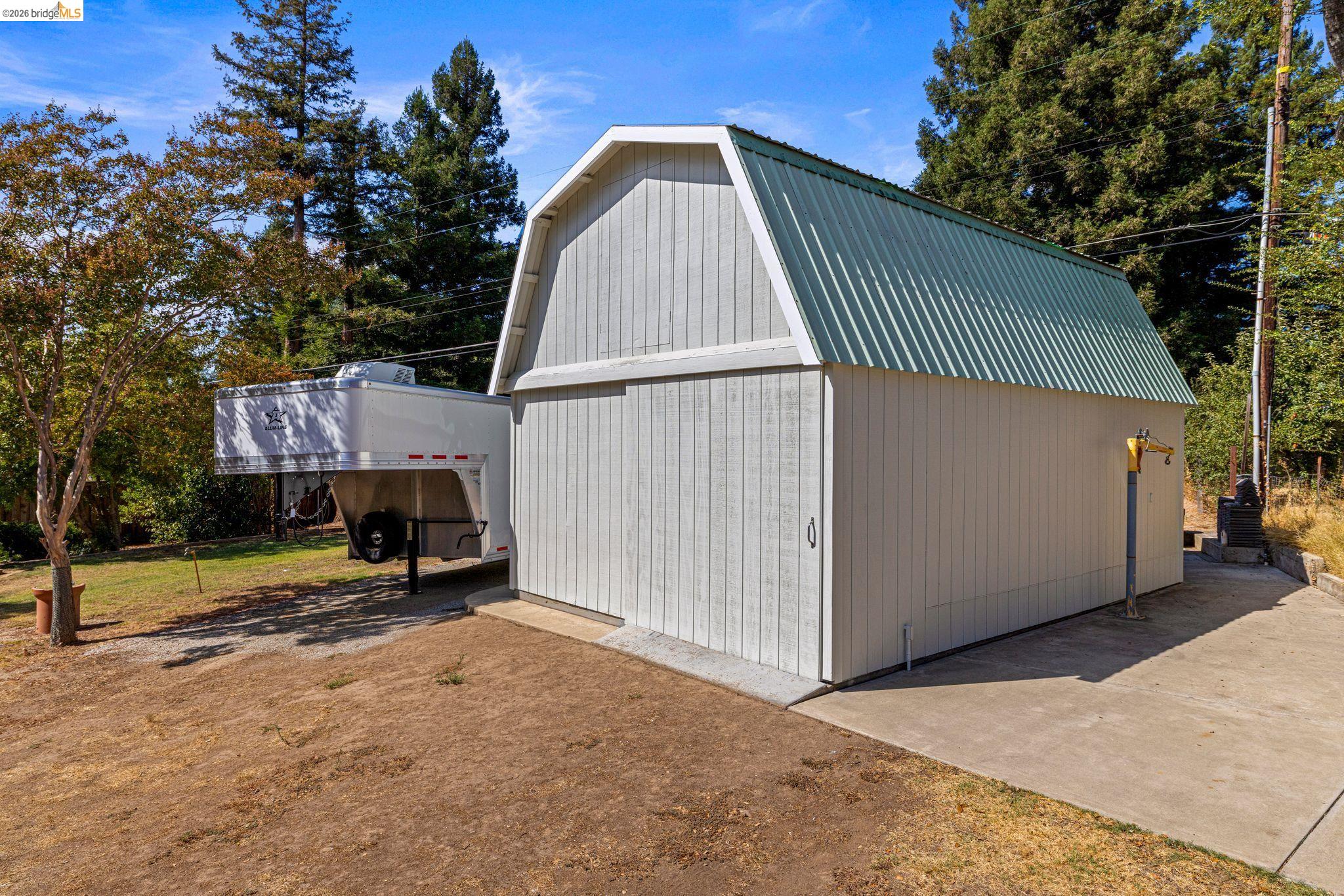 7501 Heather Road Fair Oaks, CA 95628 - Photo 71 of 82 Barn-style outbuilding featuring vertical siding and a corrugated metal gambrel roof
