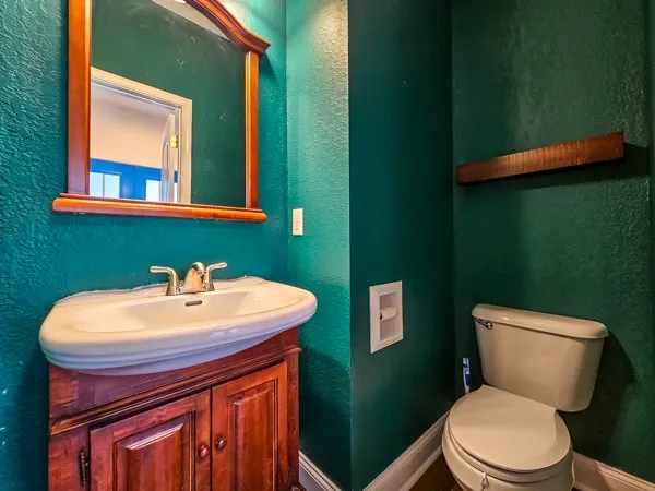 a bathroom with a sink toilet and mirror