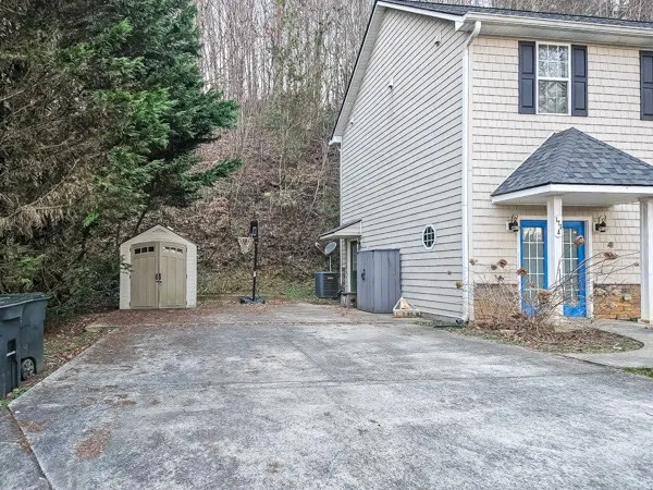 a view of a house with a yard and large tree