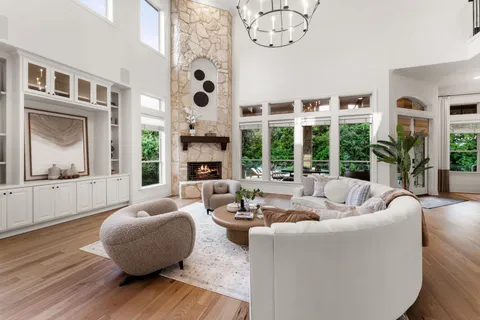 a living room with furniture large window and wooden floor