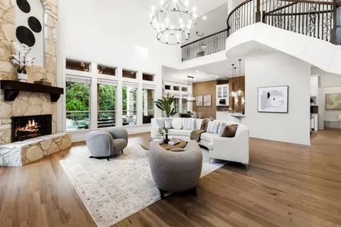 a living room with furniture large window and wooden floor