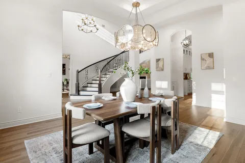 a view of a dining room with furniture a chandelier and wooden floor