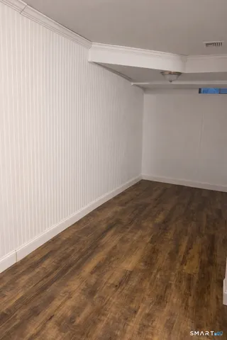 a view of a room with wooden floor and a window