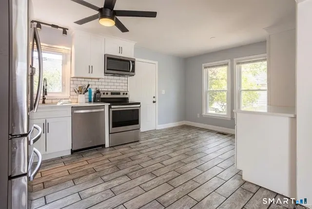 a kitchen with stainless steel appliances a stove top oven a sink and a refrigerator