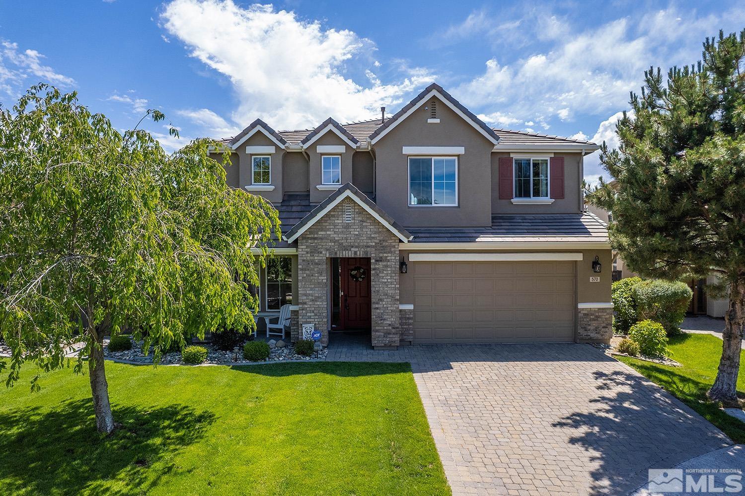 a front view of a house with a garden and yard