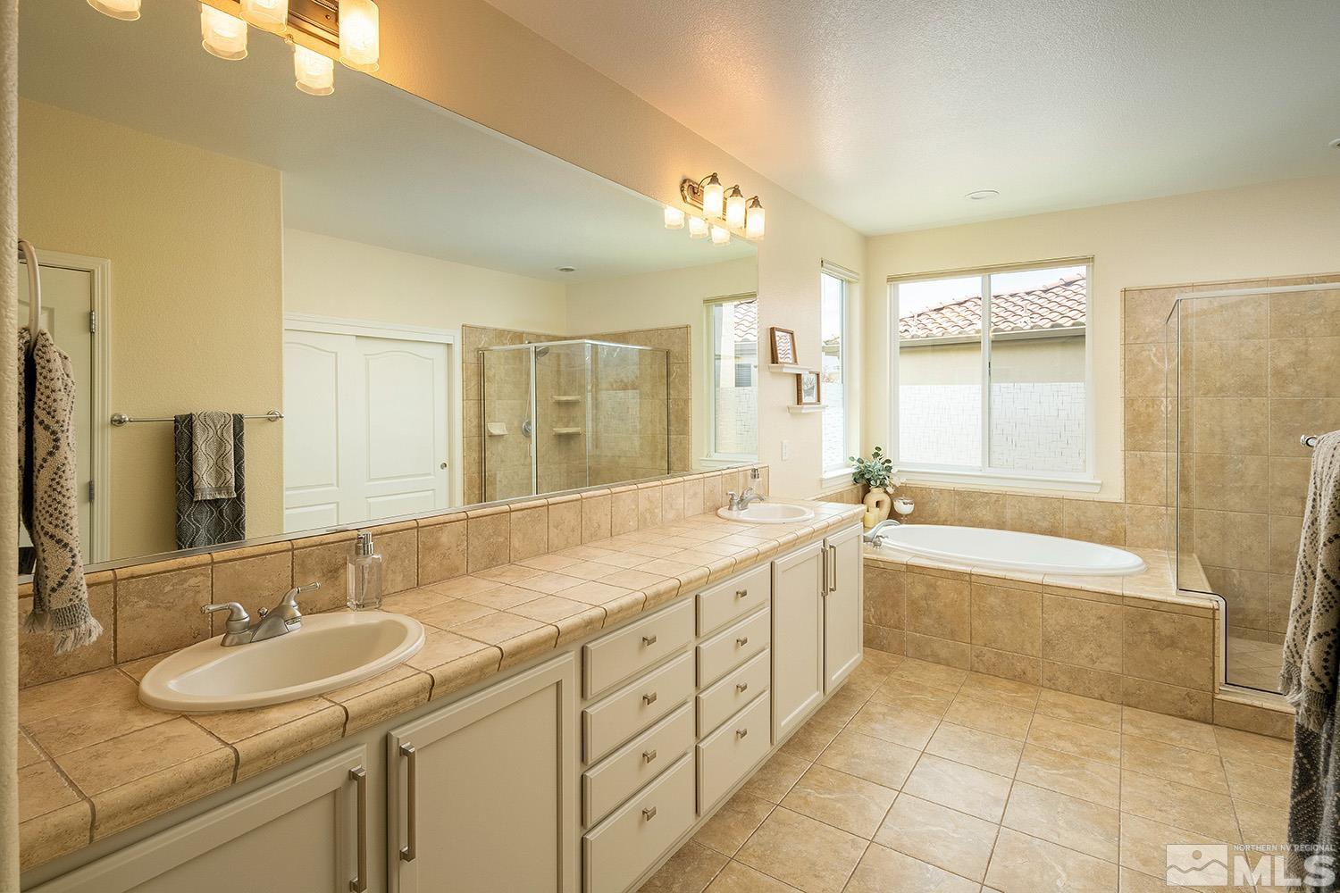 570 Alydar Court Reno, NV 89521 - Photo 20 of 40 a bathroom with a sink double vanity granite tub shower and a mirror