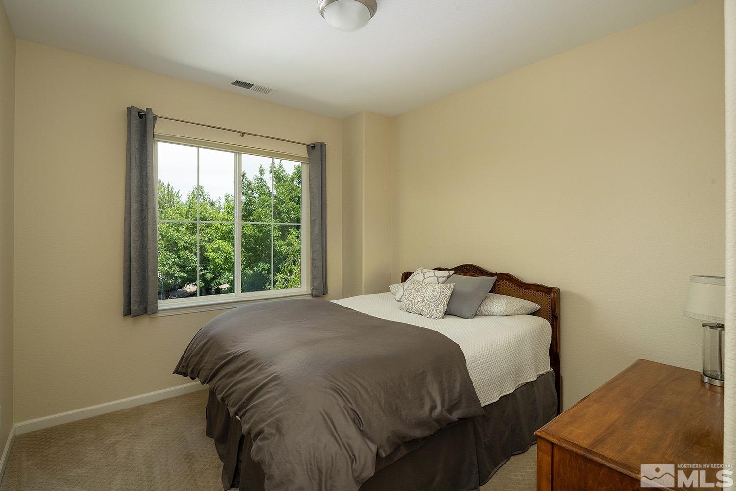 570 Alydar Court Reno, NV 89521 - Photo 26 of 40 a bed sitting in a bedroom next to a window