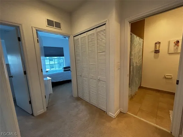 a view of a hallway with bathroom and a door