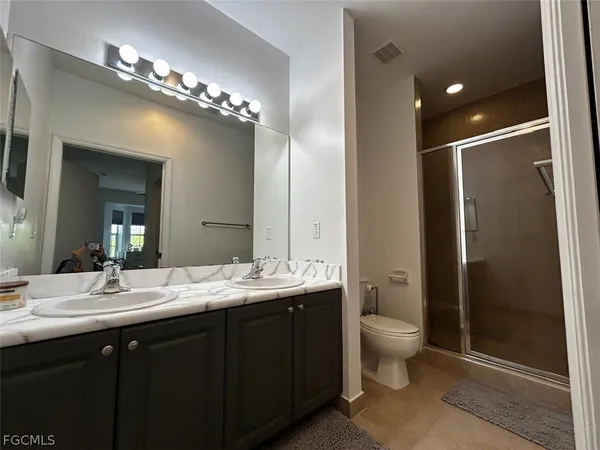 a bathroom with a double vanity sink mirror and toilet