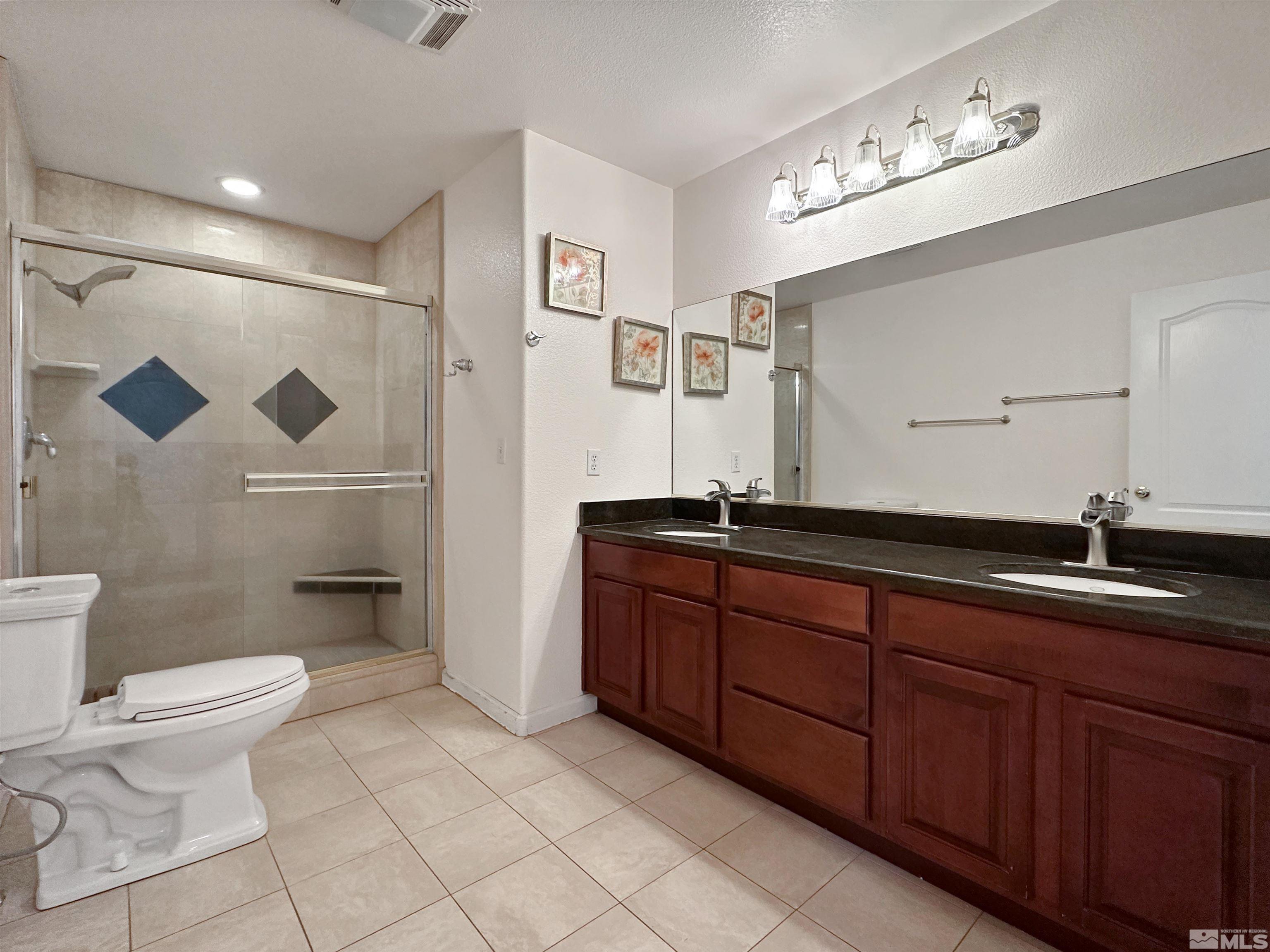 200 Descanso Lane Sparks, NV 89441 - Photo 25 of 28 a bathroom with a granite countertop sink a toilet and a mirror