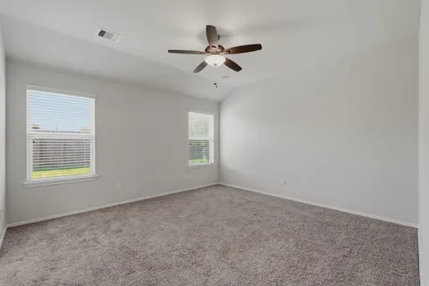 an empty room with a hallway and a ceiling fan