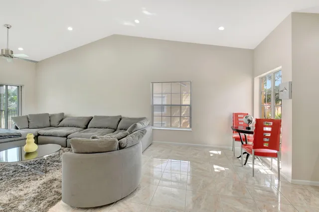 a dining room with wooden floor a chandelier a wooden table and chairs