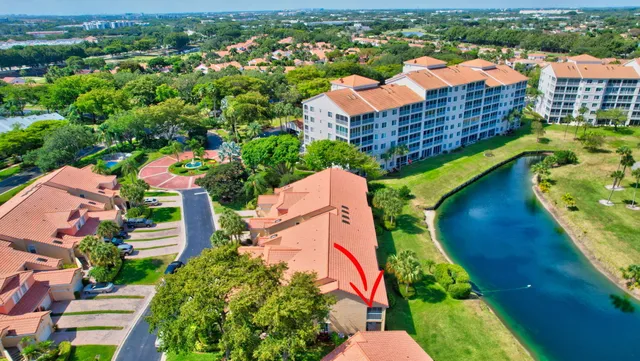 an aerial view of a house with a yard and lake view