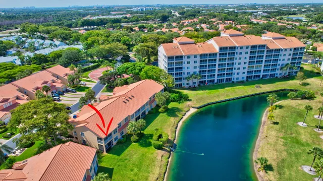 an aerial view of a house with a garden and lake view